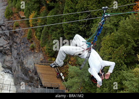 Ein Mädchen kopfüber auf eine Zip-line Stockfoto