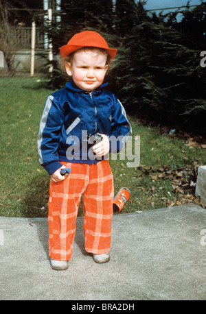 1950ER JAHREN WENIG BOOY IN RED HAT DRAUßEN HALTEN SPIELZEUG 1951 Stockfoto