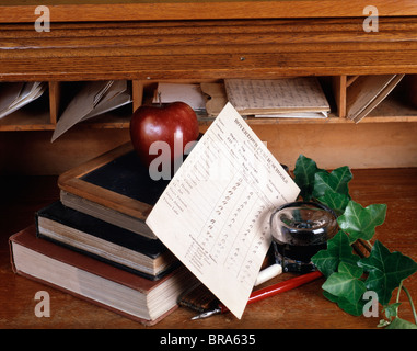 OLDSCHOOL ZEIT STILLLEBEN MIT TINTENFASS STIFT SCHULZEUGNIS SCHIEFER BÜCHER EFEU AN SCHREIBTISCH AUS HOLZ Stockfoto