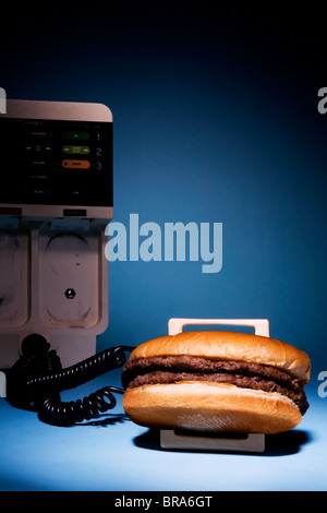 Defibrillator angeschlossen an einen Hamburger auf Hintergrund Stockfoto