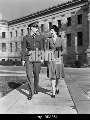 1940ER JAHREN LÄCHELND PAAR MANN TRAGEN EINHEITLICHE ARMEE Stockfoto