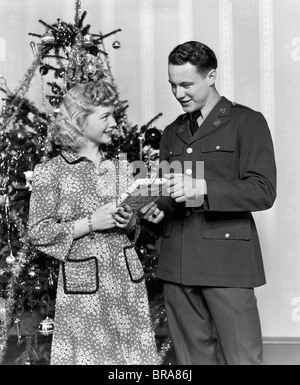 1940ER JAHREN PAAR MANN SOLDAT GESCHENK FRAU WEIHNACHTSBAUM Stockfoto