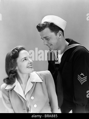 1940ER JAHRE LÄCHELNDE PAAR MANN FRAU NAVY UNIFORM Stockfoto