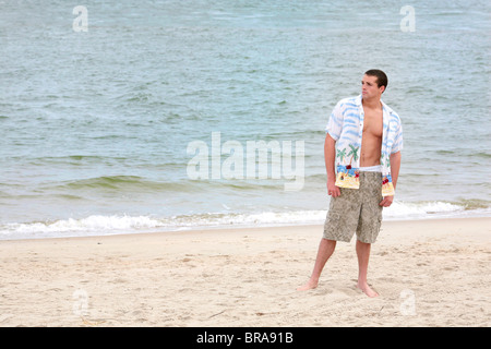 ein junger Mann stand auf dem Strand in voller Länge portrait Stockfoto