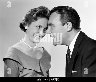 1950S 1960S STELLTE PAAR MANN FRAU LÄCHELND DEN KOPF Stockfoto