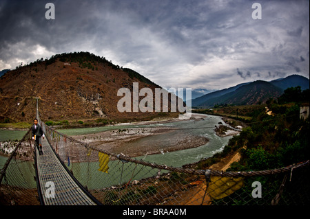 Ein Student überquert Bhutans längste Hängebrücke, Panakha, Bhutan, Himalaya, Asien Stockfoto