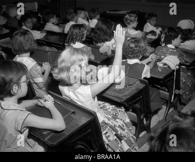 1950ER JAHREN GRUNDSCHÜLER IM KLASSENZIMMER BLONDE MÄDCHEN ERZIEHUNG HAND Stockfoto