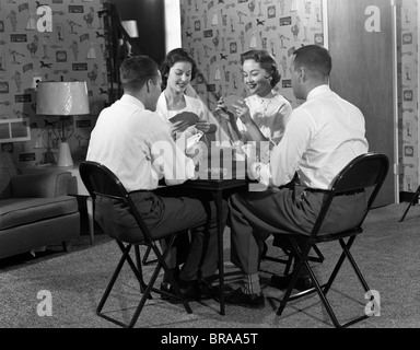 DER 1950ER JAHRE ZWEI PAARE BEI KARTE TISCH SPIELEN KLAPPSTEG SITZEN Stockfoto