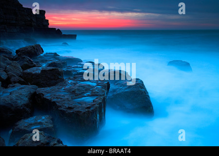 Rosa Glut vor Sonnenaufgang bei Winspit, Dorset, England. Juraküste Welterbe-Aufstellungsort. Stockfoto