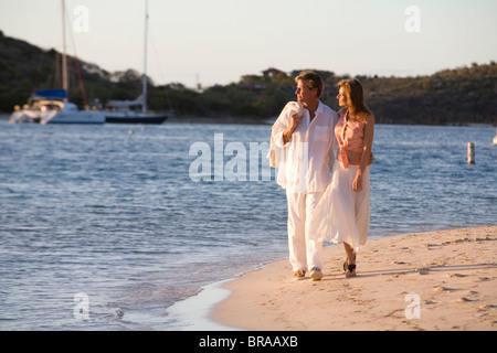 Paar bitteren Ende Strand entlang spazieren, bei Sonnenuntergang, Britische Jungferninseln, April 2006. -Modell veröffentlicht. Stockfoto