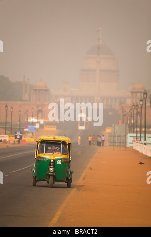 Eine Auto-Rikscha fährt entlang der Rajpath, vor den Rashtrapati Bhavan, an einem trüben Tag in Neu-Delhi, Indien Stockfoto