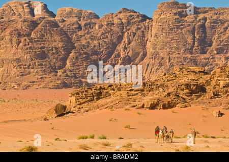 Kamel-Karawane in die atemberaubende Wüstenlandschaft von Wadi Rum, Jordanien, Naher Osten Stockfoto
