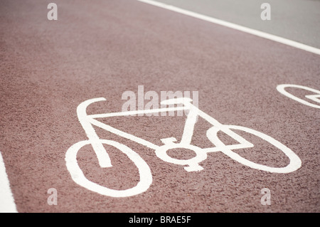 Ausgewiesenen Cycle Lane Symbol, gemalt auf einem roten Asphalt Fahrbahn, Brighton, Sussex, England Stockfoto