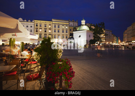 Straßencafés in Hauptmarkt (Rynek Glowny) mit Kirche von St. Adalbert in Hintergrund, UNESCO, Krakau, Polen Stockfoto