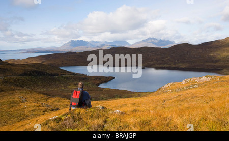 Wanderer, Blick über Loch Dhughaill in Richtung der entfernten Cuillin Hills, Sleat Halbinsel, in der Nähe von Tarskavaig, Isle Of Skye, Schottland Stockfoto