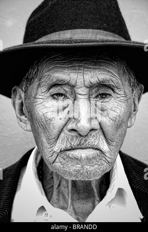 Alter Mann mit Falten und großen Augen helle Wand mit schwarzer Cowboy-Hut in touristischen Dorf von Antigua Guatemala Stockfoto