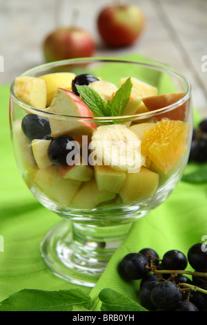 Obstsalat in eine Glasschüssel auf einem grünen Tuch Stockfoto