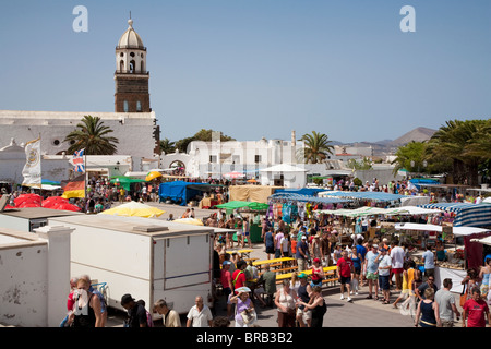 Menschenmassen am Sonntagsmarkt mit dem Glockenturm der Iglesia de San Miguel im Hintergrund, Teguise, Lanzarote Stockfoto