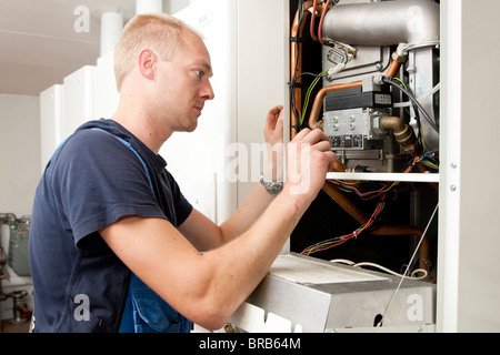 Heizungs- und Sanitär-Techniker testen und Anpassen einer Gasheizung Stockfoto