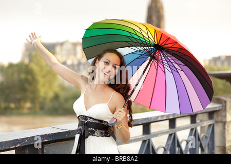 Französisch Frau zu Fuß auf die Brücke hält Regenbogen Regenschirm in Bordeaux, Frankreich Stockfoto
