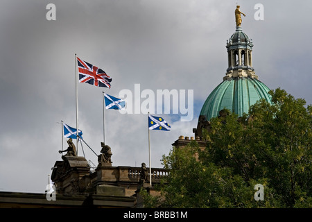 Die Bank of Scotland auf dem Hügel in Edinburgh. Schottische Andreaskreuz Flagge, Anschluß-Markierungsfahne und Bank corporate Flagge. Gewitterwolken Stockfoto