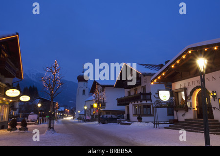 St. Anton am Arlberg-Hauptstraße und Kirche im Winter am Abend, Tirol, Österreichische Alpen, Österreich Stockfoto