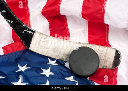 Hockey-Ausrüstung, einschließlich einen Stock und Puck auf eine amerikanische Flagge, eine patriotische amerikanische Sportart abzuleiten. Stockfoto