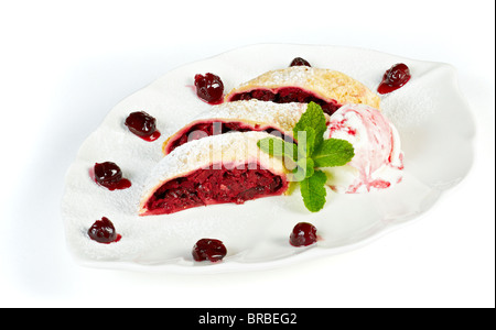 leckere Biskuitrolle mit Kirschen auf dem Silbertablett serviert mit Eis Stockfoto