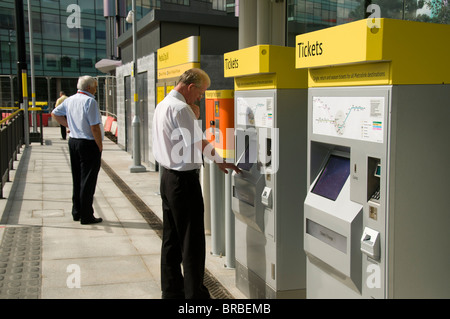 Mann an ein Fahrscheinautomat an der Metrolink Straßenbahn Station bei MediaCityUK, Salford Quays, Manchester, England, UK Stockfoto