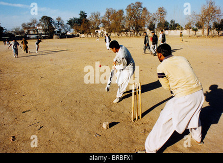 Männer spielen Cricket auf Schmutz-Feld Stockfoto