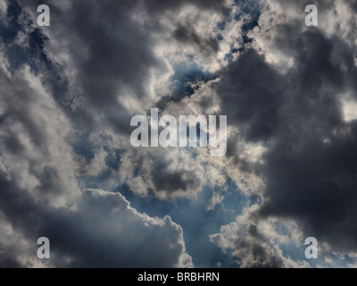 Wolken im Himmel blau mit Sonne hinter Schatten Sonnenstrahlen flauschig Stockfoto