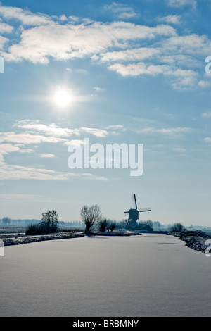 Frozen River und holländischen Windmühle auf einem kalten Wintertag Stockfoto