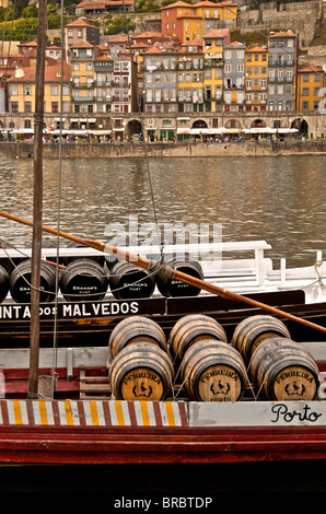 Hafen Weinfässer auf einem Boot auf dem Fluss Douro mit Vila Nova De Gaia im Hintergrund, Porto, Portugal Stockfoto