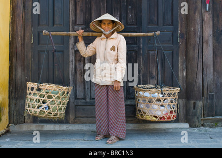 Frau-Anbieter tragen Lebensmittel auf den Markt, Hoi an, Vietnam, Indochina Stockfoto