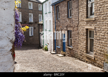 Ferienhäuser in den gepflasterten Hauptstraße der Yorkshire Dales National Park Village delle Dentdale, Cumbria. Stockfoto