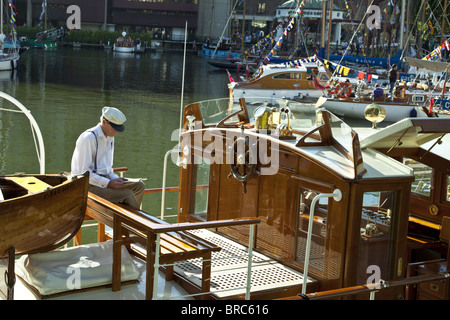 Gentleman, ein Buch auf einer Yacht in St Katherine's Dock, London, UK. Stockfoto