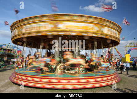 Traditionelle britische "merry Go round". Ein Messegelände fahren basierend auf Holzpferde und nicht ausschließlich von Kindern genossen. Stockfoto