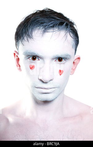 junger Mann mit weißem Make-up und roten Herzen statt Tränen Stockfoto