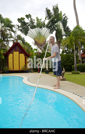 Mann, die Reinigung ein Schwimmbad in Phuket Thailand Stockfoto