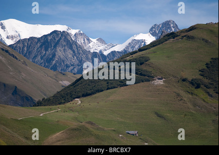 Abgelegenen Farm und Tarine Milchvieh Herde in Beaufortain Tal, Savoie, Frankreich mit Mont-Blanc-Massiv im Hintergrund Stockfoto