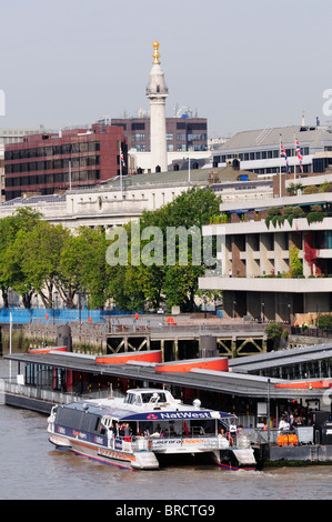 Ein Thames Clippers Riverbus am Tower Pier, mit der große Feuer-Denkmal in den Hintergrund, London, England, Uk Stockfoto