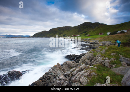 Fotograf bei der Arbeit im Freien in der Nähe der kleinen Gemeinschaft Goksøyr auf der Insel Runde, atlantischen Westküste, Norwegen. Stockfoto