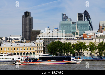 Ein Thames Clippers-Riverbus mit der Londoner Gebäude in den Hintergrund, London, England, UK Stockfoto