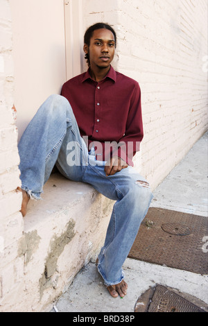 Young African-American Männchen sitzen in einem Hauseingang. Newport Beach, Kalifornien. Stockfoto