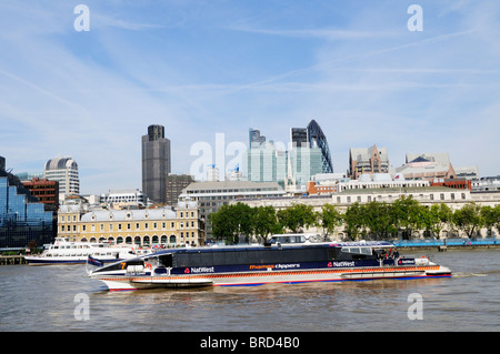 Ein Thames Clippers-Riverbus mit der Londoner Gebäude in den Hintergrund, London, England, UK Stockfoto