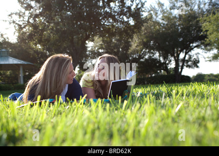 Mutter und Tochter Kommentar über ein Buch, dass sie im Park lesen. Stockfoto