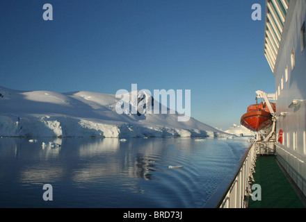 Kreuzfahrtschiff mit Rettungsboot, Berge & Gletscher spiegelt sich in ruhiges Meer, Paradise Harbour, Antarktis Stockfoto