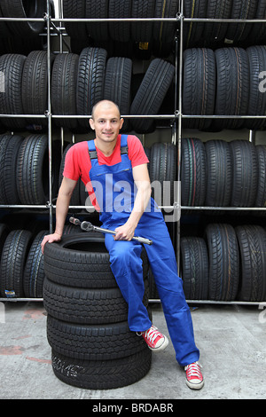 Ein motivierter Arbeiter in einem Reifen-Workshop. Stockfoto