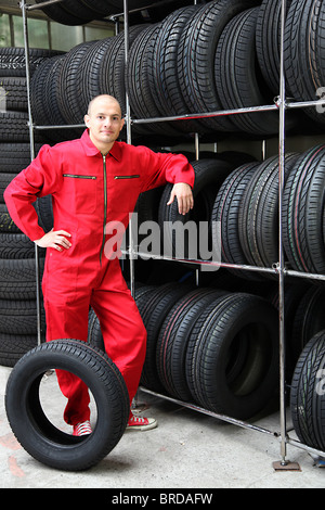 Ein motivierter Arbeiter in einem Reifen-Workshop. Stockfoto