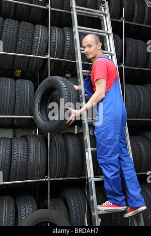 Ein motivierter Arbeiter in einer Reifen Werkstatt Auffüllen der Ware. Stockfoto